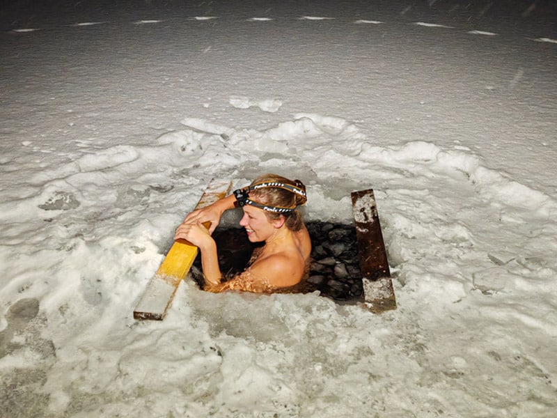 Woman ice-bathing in frozen lake