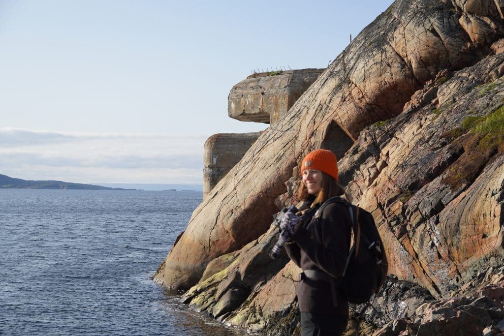 Eine Frau steht in der Nähe der Torpedobatterie aus dem Zweiten Weltkrieg in Bøkfjord