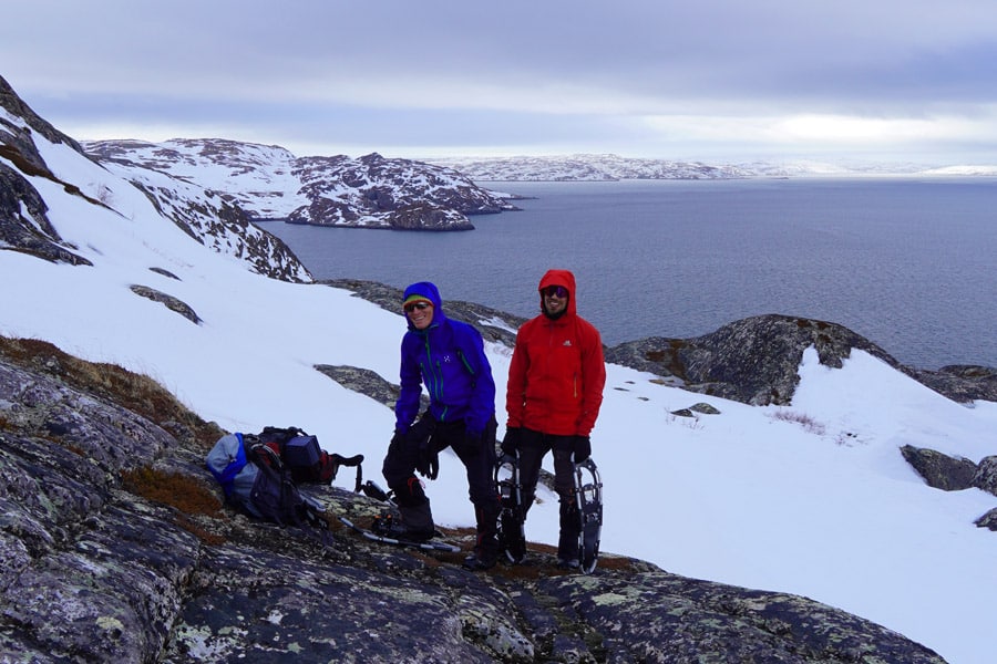 Male snowshoe hikers at the coast of Bøkfjord, Kirkenes, Northern Norway