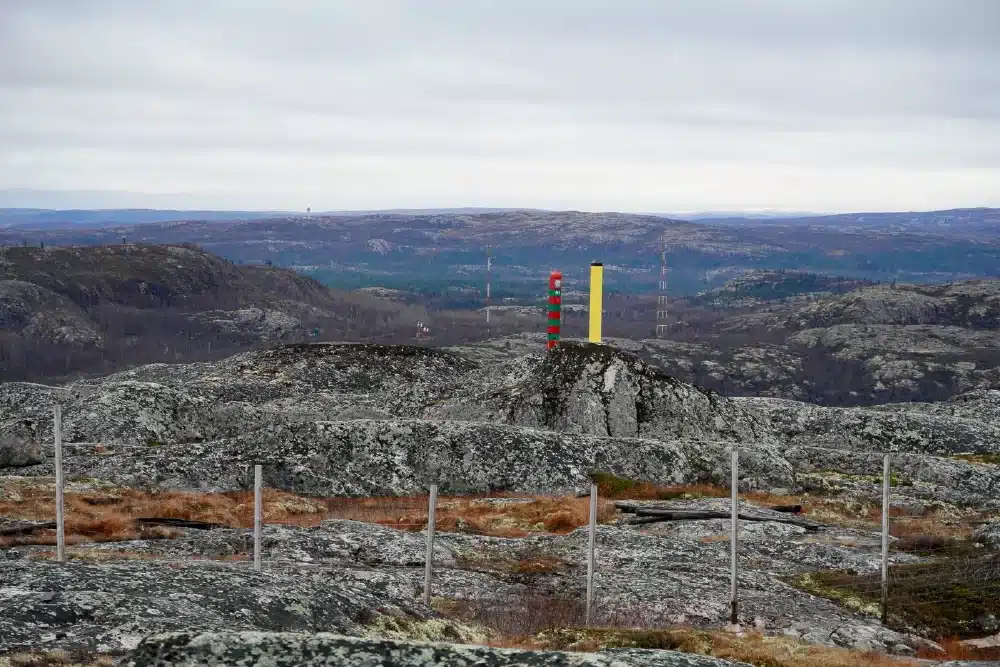 Grenzsteine entlang der norwegisch-russischen Grenze in einer felsigen Landschaft bei Kirkenes mit weiten Ausblicken über Sør Varanger