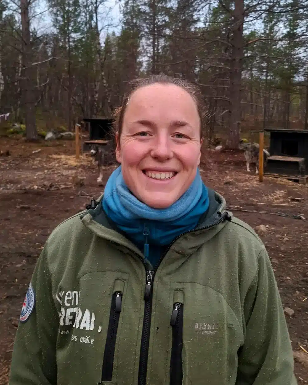 Hannah, local dog sledding guide, standing at the husky kennel in Pasvik near Kirkenes in Northern Norway.