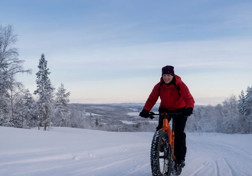 Man fatbiking through flat winter landscape in Sør-Varanger