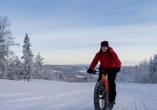 Mann fährt mit dem Fatbike durch flache Winterlandschaft in Sør-Varanger