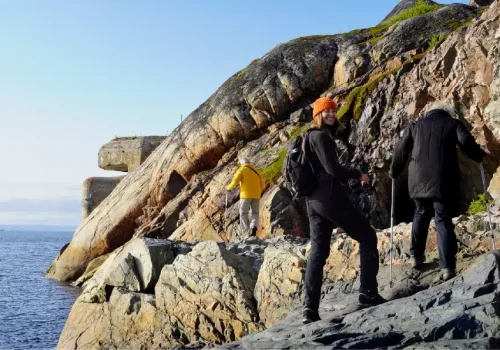 Hikers arriving at the abandoned WWII torpedo battery near Kirkenes