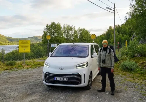 Ein Guide steht neben einem Minivan am alten Grenzübergang Skafferhullet in der Nähe von Kirkenes in Nordnorwegen.
