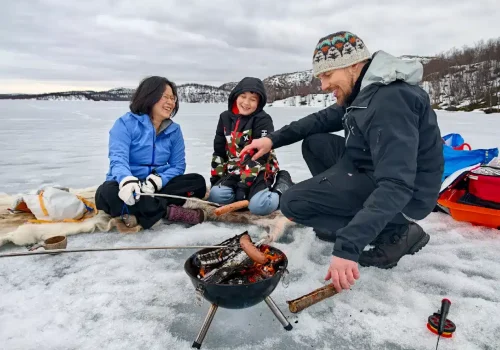 Ice fishing at Pikevatnet near Kirkenes with family grilling sausages on frozen lake